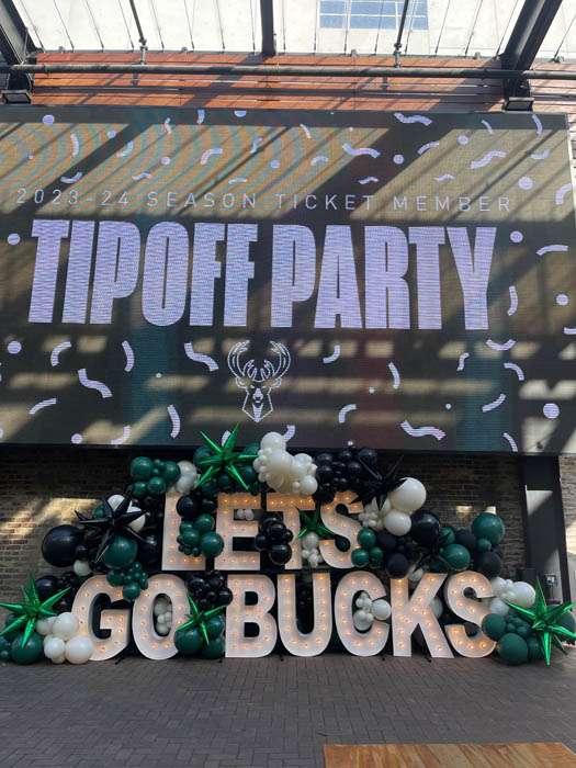 Outdoor balloon display for the Milwaukee Bucks "let's Go Bucks" using green, black and lace colored balloons with green and black starburst balloons.