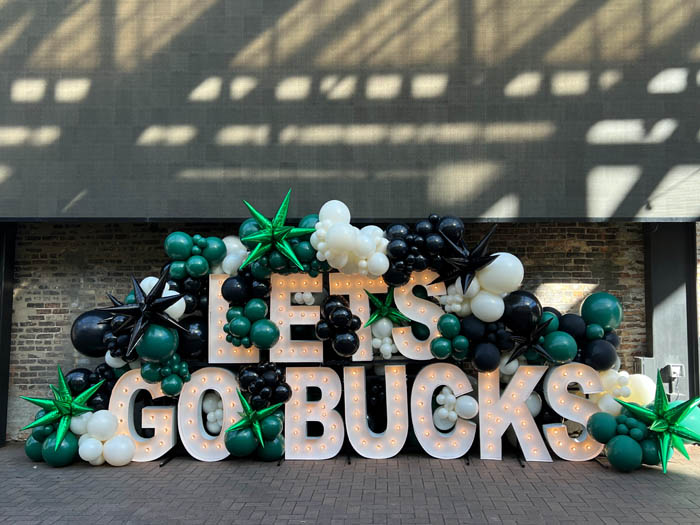 Outdoor balloon display for the Milwaukee Bucks "let's Go Bucks" using green, black and lace colored balloons with green and black starburst balloons.